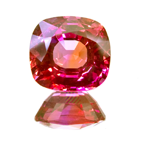 Faceted pink-orange padparadscha sapphire on a white background. Colour reference only, not stock.